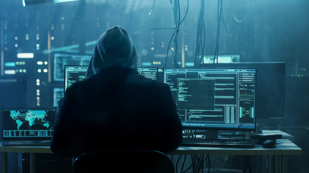 Hacker using computers to break into other computer systems